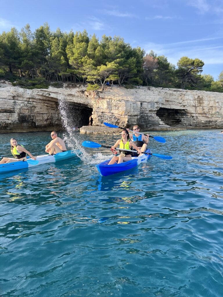 Kayakers exploring the rocky coastline and crystal-clear sea near Pula, Croatia